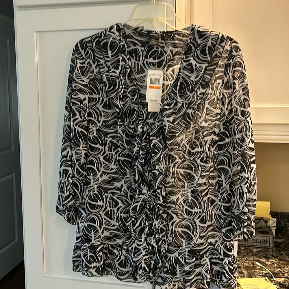 Never worn, tags still attached!  Black and white ruffle front blouse.Size small